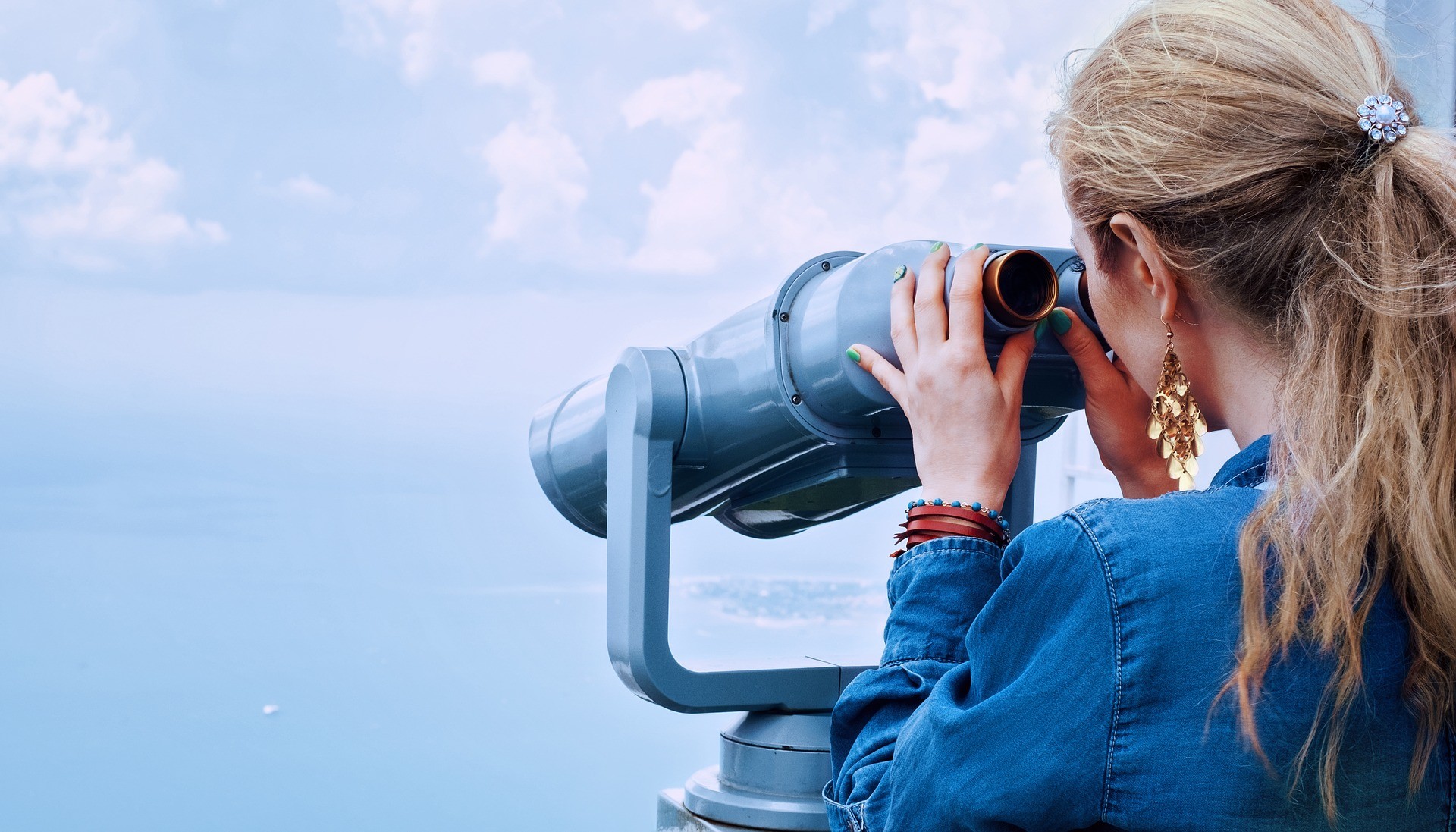Frau schaut durch ein Fernglas